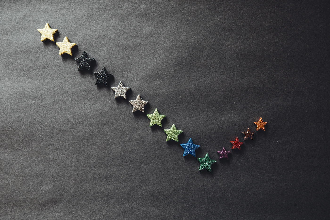 Étoiles multicolores disposées en courbe, symbole visuel des avis et évaluations